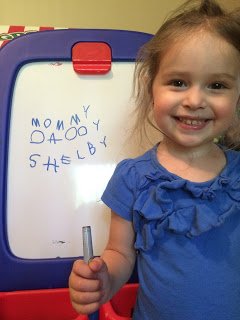 Image of toddler with white board. 4 tools to encourage early writing