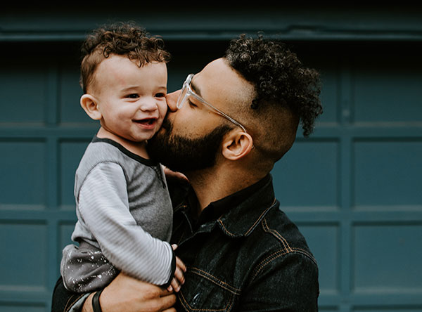 father kissing baby - why fathers are important to their kids
