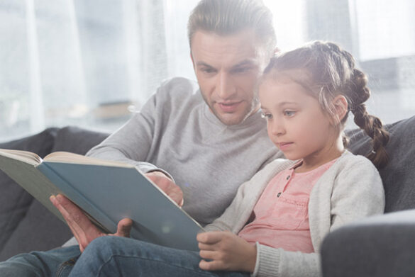 father teaching daughter to read
