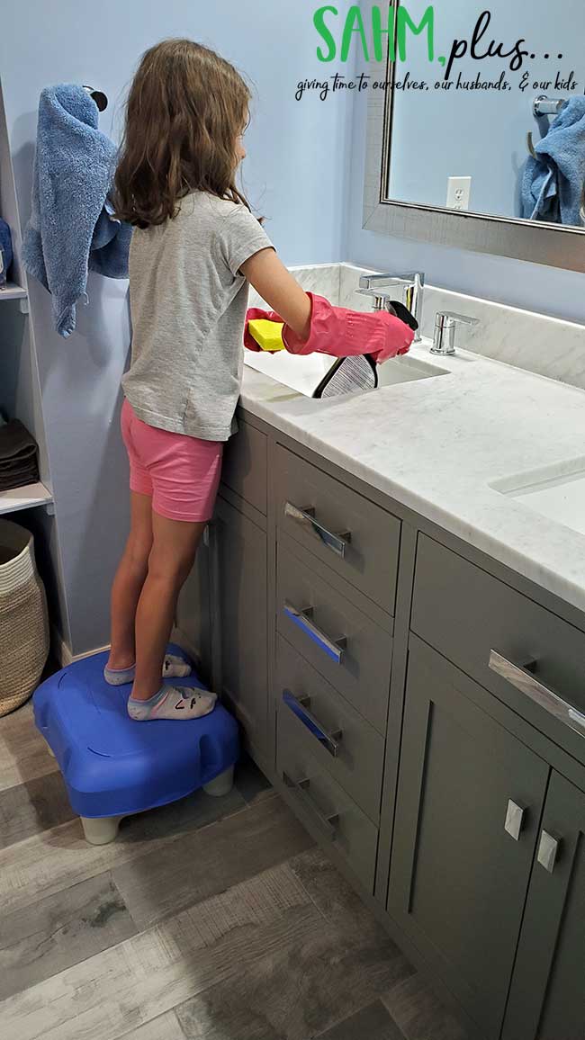 girl cleaning bathroom sink for chores