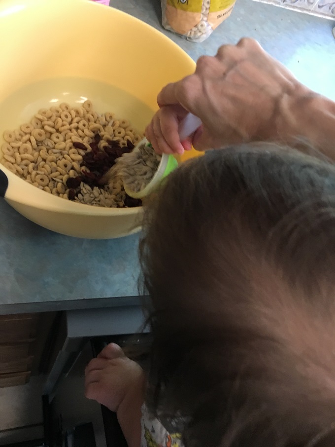 My little partner in the kitchen using The Original Learning Tower as he helps pour ingredients into a bowl