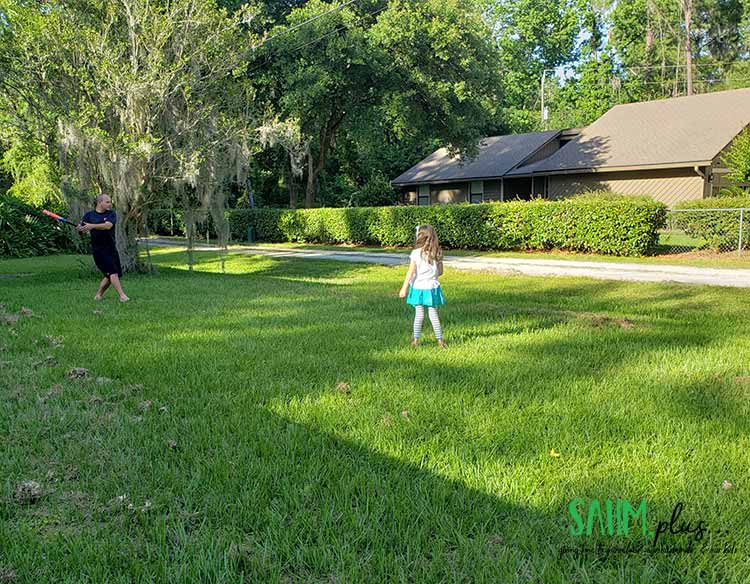 father and daugher playing ball in the yard