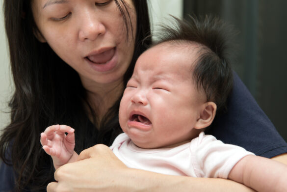 mom holding crying baby - sleep regression