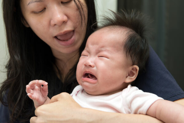 mom holding crying baby - sleep regression