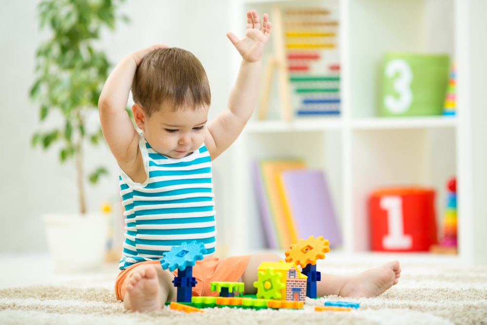 smart baby with hands up playing with toys