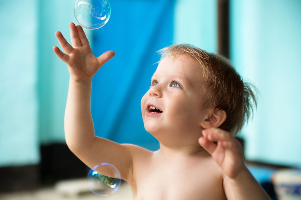 Toddler with bubbles - great outdoor activity for toddlers